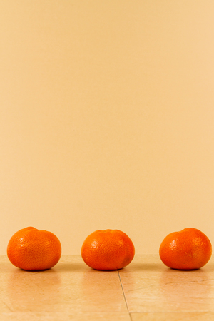 Line of tangerines with green leaves copy space above.の写真素材