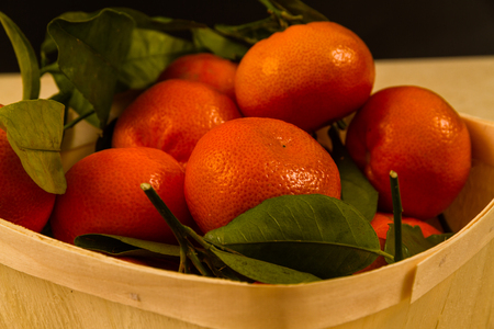 Basket of tangerines with green leaves.の写真素材