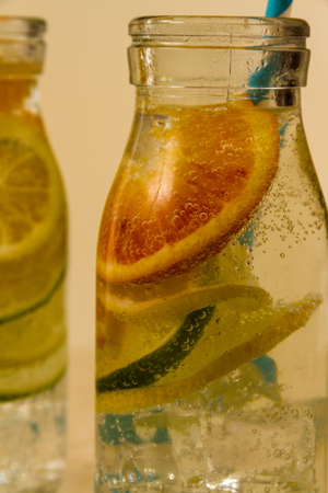 Childrenâs sparkling water drinks in bottles with straw. Slices of orange, lemon and lime.の写真素材