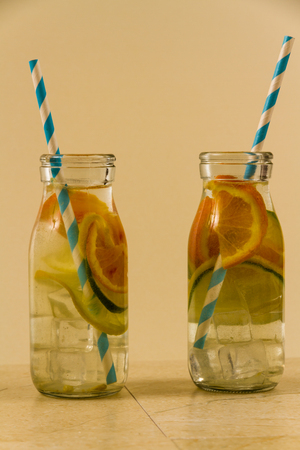 Childrenâs water drinks in bottles with straw. Slices of orange, lemon and lime.の写真素材