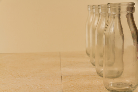 Copy space area with four small glass milk bottles on right.の写真素材