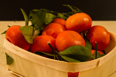 Basket of tangerines with green leaves.の写真素材