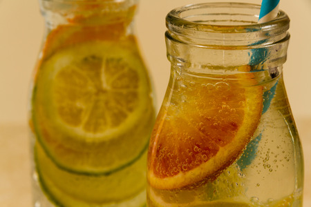 Childrenâs sparkling water drinks in bottles with straw. Slices of orange, lemon and lime.の写真素材