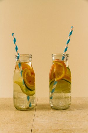 Childrenâs water drinks in bottles with straw. Slices of orange, lemon and lime.の写真素材