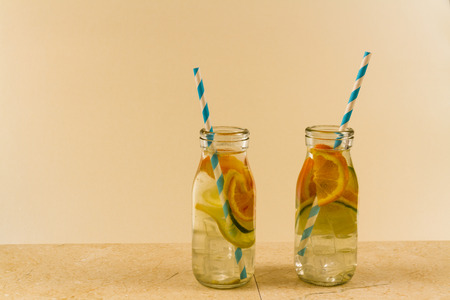 Childrenâs water drinks in bottles with straw. Slices of orange, lemon and lime.の写真素材
