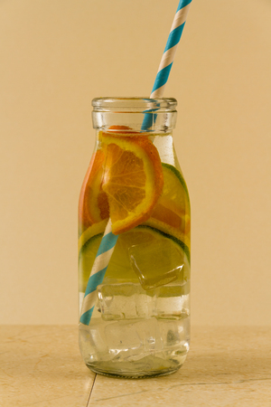 Childrenâs water drink in bottle with straw. Slices of orange, lemon and lime.の写真素材