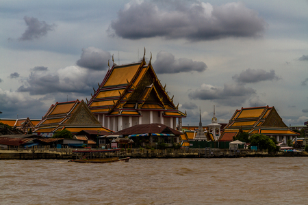 Wat Kalayanamitr Varamahavihara Buddhist Temple with boat in front. Chao Phraya River, Bangkok, Thailand.の写真素材