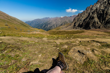 Tien Shen Mountains at Shymbulak Upper Piste Talgar pass near Almaty, Kazakhstanl Legs in foreground.の写真素材
