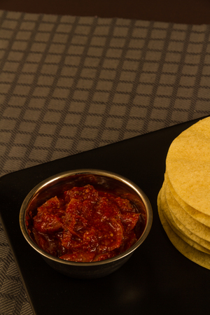 Indian poppadums stacked with bowl of lime pickle and sliced limeの写真素材