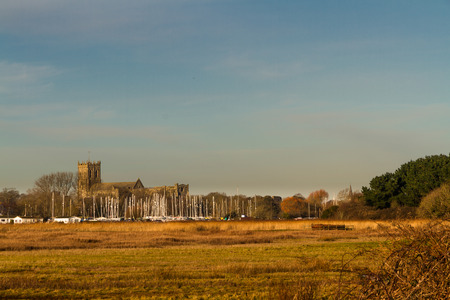 View from Stanpit Marsh of Christchurch Priory. Dorset, England, UK