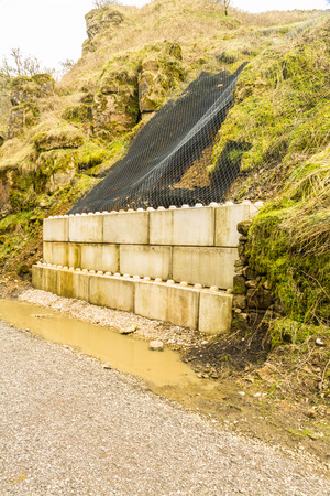 Concrete and netting holding back landslip on walking trail.の写真素材