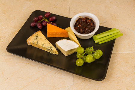 Cheeseboard, platter, cheese, red Leicester, stilton, cheddar, camembert, grapes, celery, pickle or chutney.の写真素材