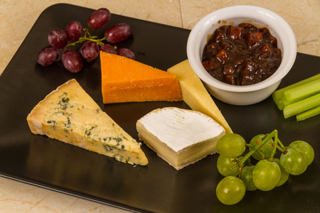 Cheeseboard, platter, cheese, red Leicester, stilton, cheddar, camembert, grapes, celery, pickle or chutney.の写真素材