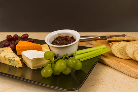 Cheeseboard, platter, cheese, red Leicester, stilton, cheddar, camembert, grapes, celery, pickle or chutney and biscuits.の写真素材