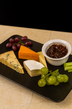 Cheeseboard, platter, cheese, red Leicester, stilton, cheddar, camembert, grapes, celery, pickle or chutney.の写真素材