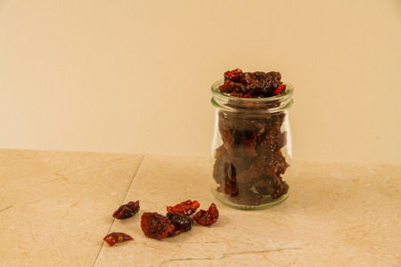sun dried tomatoes in jar and on surface.の写真素材