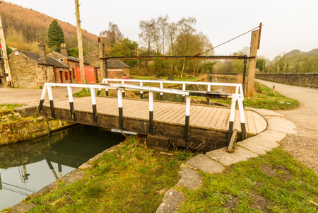 Small swing bridge over the Cromford Canal, Canal, Peak District, Derbyshire, England, UK.のeditorial素材