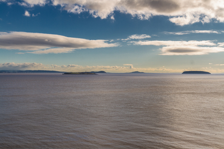Flat Holm and Steep Holm islands with lighthouse in Bristol Channel. From Wales, Somerset and Avon Coast of England in the distance, United Kingdom.の写真素材