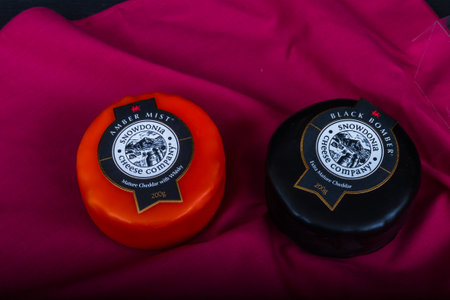 Illustrative editorial Snowdonia Cheese Company Black Bomber and Amber Mist cheese truckles on red napkin â Bournemouth, United Kingdom â November 30th, 2018のeditorial素材