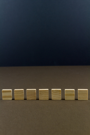 Seven wood blocks against dark background, graphic resource, template, portraitの写真素材