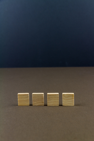Four wood blocks against dark background, graphic resource, template, portraitの写真素材