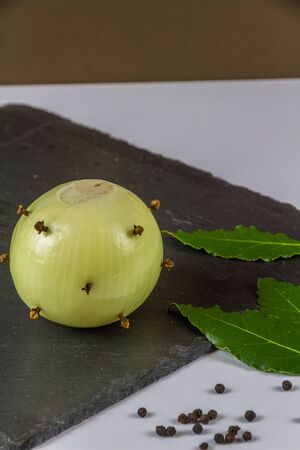 Dry Ingredients for bread sauce onion studded with cloves bay leaves and peppercorns, portraitの写真素材