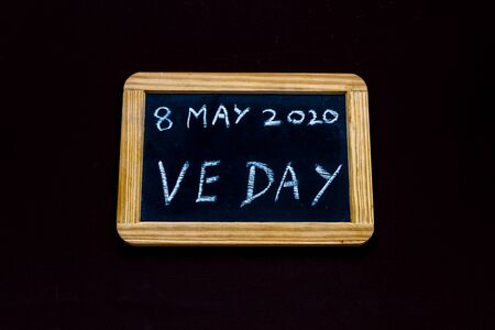 UK may bank holiday moved from 4 to 8 May 2020 to celebrate 75 years of end of WWII VE Day on old fashioned school writing slate, copyspaceの写真素材