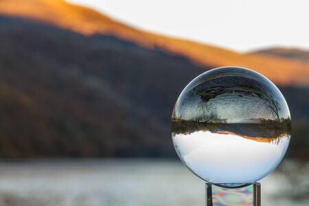 Evening Welsh Hills lit by setting sun, focussed and inverted in crystal ball, copy space.の写真素材