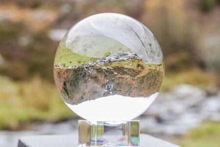 Rhiwargor waterfall on the river Eiddew, focussed and inverted in crystal ball. Lake Vyrynwy, Powys, Wales UK, landscape.の写真素材
