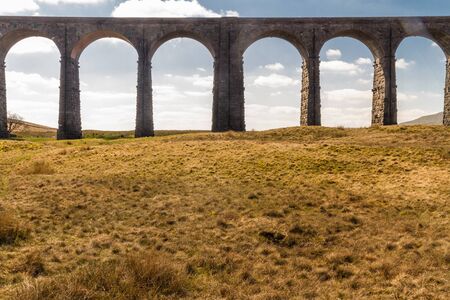 Arches against blue sky and cloud of the Ribblehead Viaduct, landscape. North Yorkshire, Europe, England, landscape and telephoto.の写真素材