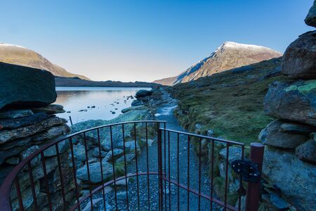 Early morning Carnedd Llewelyn, from path and lake or Llyn Idwal and gate.  Snowdonia national Park, Gwynedd, Wales, UK. landscape.の写真素材