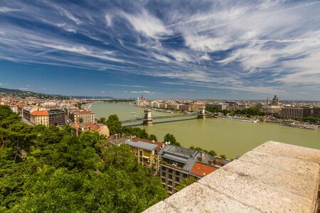 River Danube in Budapest Hungary with parliament building, trees in foreground from Buda Castle wide angle.の写真素材