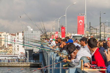 Istanbul, Turkey â Men fishing in Golden Horn Bosphorus from the Galata Bridge landscape, on October 29 2019 in Turkeyのeditorial素材
