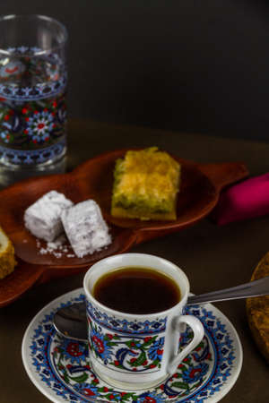 Turkish coffee in cezve with cup, saucer, water glass served with Turkish delight and baclava. Low...