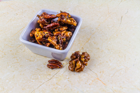 Garlic and rosemary roasted walnuts and pecan nuts as a bar, snack white bowl, landscape, copyspace
