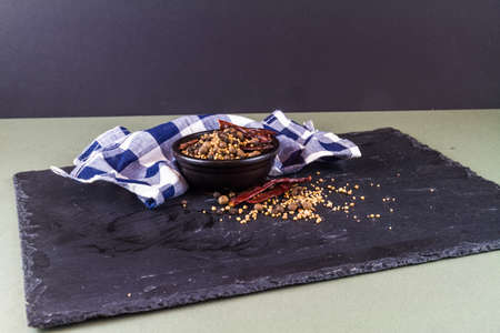 Bowl with pickling spices, and scattered over slate mat, landscape.の写真素材