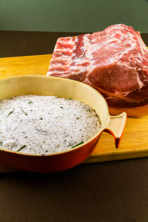 View of dish with dry cure for bacon, salt, sugar, bay leaf, pepper, juniper. On wooden chopping board, portraitの写真素材