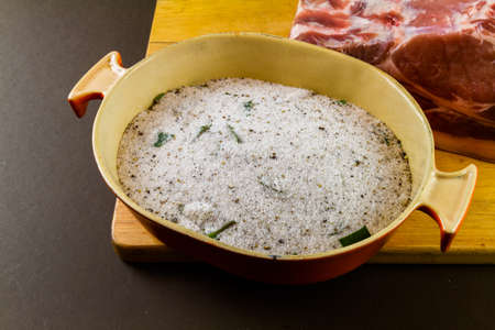 View of dish with dry cure for bacon, salt, sugar, bay leaf, pepper, juniper. On wooden chopping boardの写真素材