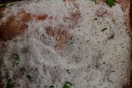 Close up of Dry salt cure on Pork loin or back joint at start of curing process to make bacon.の写真素材