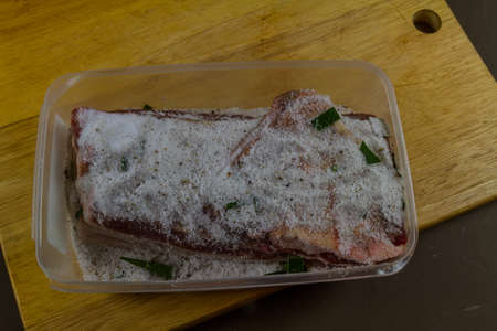 Close up of Dry salt cure on Pork belly joint at start of curing process to make streaky bacon, landscape.の写真素材