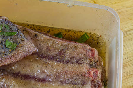 Dry salt cure on Pork belly joint in dry salt cure  becoming streaky bacon with liquid brine drawn...