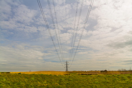 electric pylons in distance above countryside wires into foreground, landscapeの写真素材