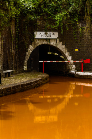 The Trent and Mersey Canal and northern entrance to the Harecastle Tunnel, Kidsgrove, Newcastle-under-Lyme. The water is orange because if clay deposited in the Harecastle Tunnel, portraitの写真素材
