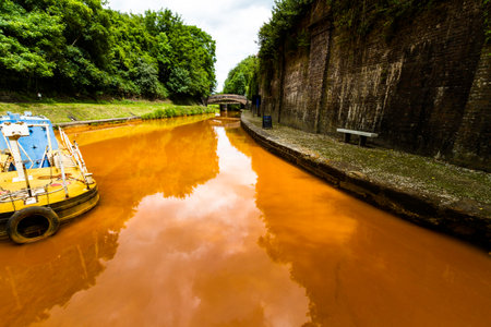 The Trent and Mersey Canal, Kidsgrove, Newcastle-under-Lyme. The water is orange because if clay deposited in the Harecastle Tunnel, landscape, wide angleの写真素材