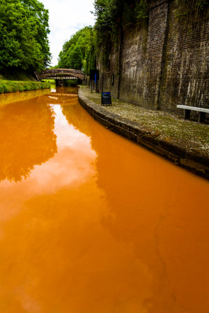 The Trent and Mersey Canal, Kidsgrove, Newcastle-under-Lyme. The water is orange because if clay deposited in the Harecastle Tunnel, portrait, wide angleの写真素材