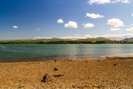 View of Snowdonia or Eryri Mountains on beautiful summer day, seen from Anglesey, across the Menai Straits water, North Wales, UK.の写真素材