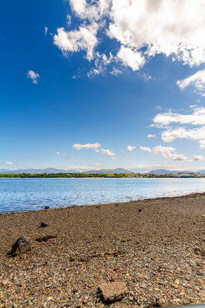 Angled View of Snowdonia or Eryri Mountains on beautiful summer day, seen from Anglesey, across the Menai Straits water, North Wales, UK, portrait.の写真素材