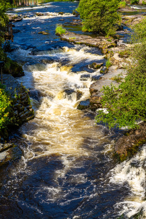 The River Dee cascading at Llangollen, Denbighshire, North Wales cascading on a Sunny Day, portrait.の写真素材