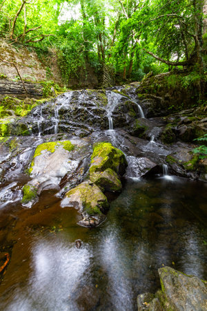 Main part of the The Fairy Falls, called Rhaeadr y Tylwyth Teg in Welsh. Waterfall in Trefriw Conwy County, North Wales, UK, low water because if summer, portrait, wide angle.の写真素材