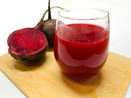 Beetroot juice in a glass with fresh beetroots on a white backgroundの写真素材